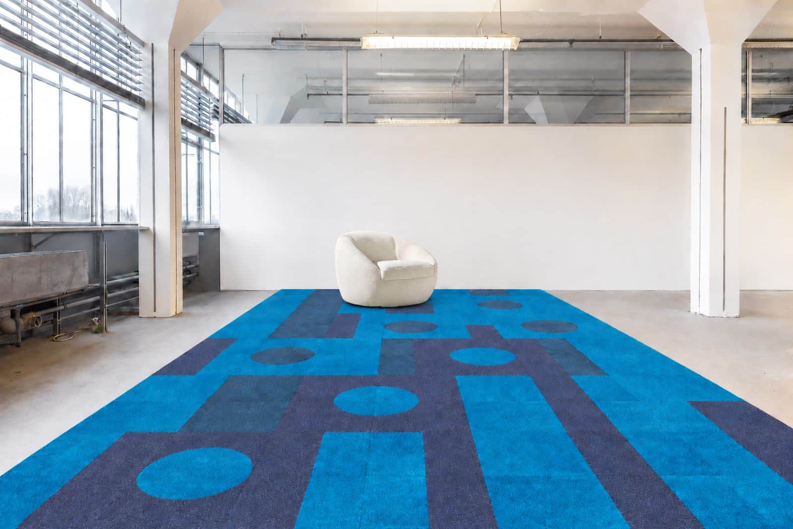 Felblauwe vloer met langgerekte lichte vormen en een witte fauteuil