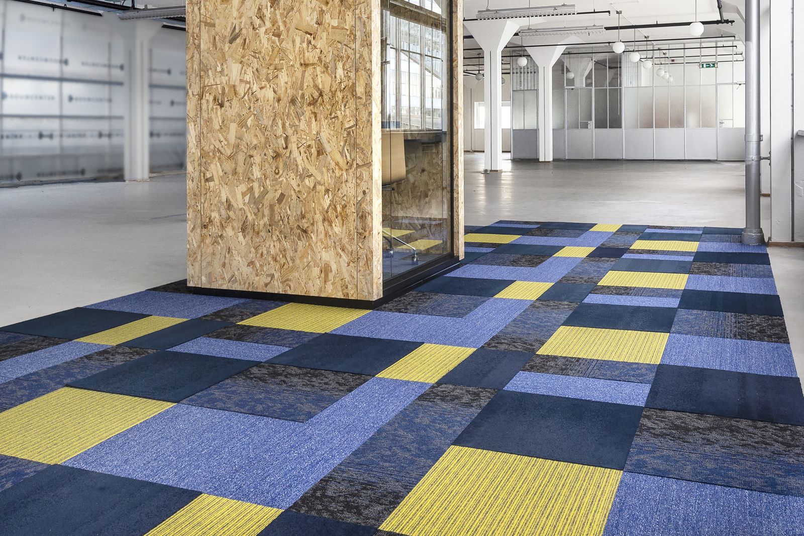 Vloer van blauwe en gele vierkante tapijttegels langs een houten wand