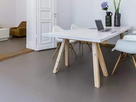 Vergadertafel met witte stoelen op een egale grijze vloer