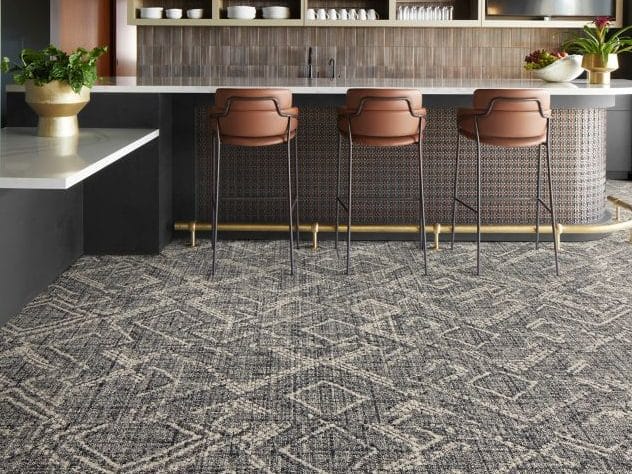 Bar met terracotta krukken op tapijttegels met een grafisch dessin in grijstinten